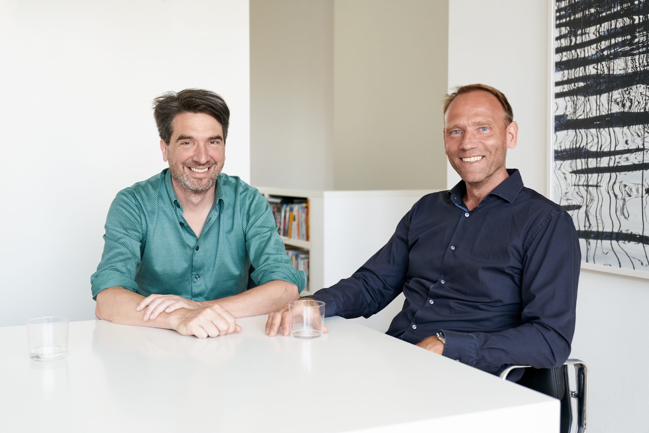 Zwei Männer sitzen an einem weißen Tisch: Christian Roth (links) und Sascha Zander (rechts)